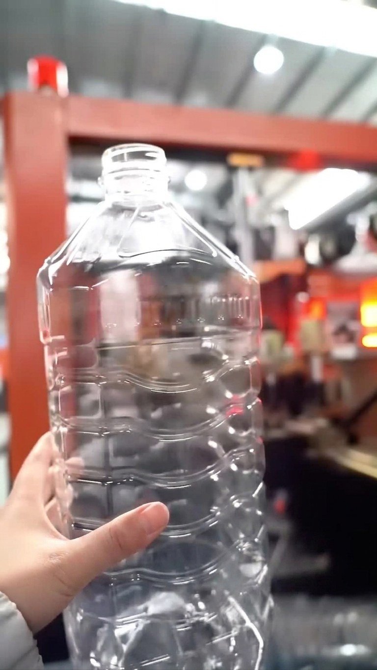 PET edible oil bottle blow molding machine finished bottle hand showcase front view Sailwin