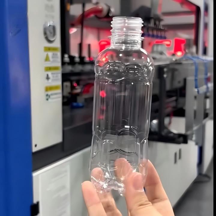 PET water bottle blowing machine finished slim bottle hand showcase red bokeh Sailwin